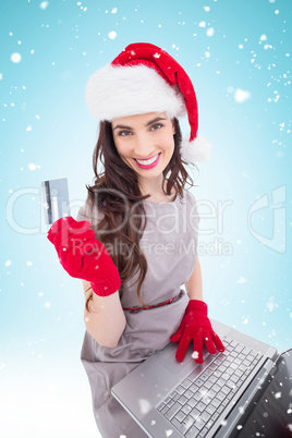 Composite image of beauty brunette shopping online with laptop