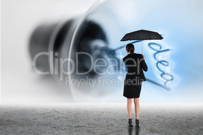 Composite image of young businesswoman holding umbrella
