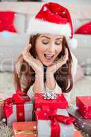 Composite image of festive redhead smiling at gifts