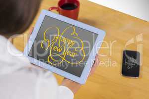 Composite image of businesswoman using tablet at desk