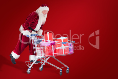 Composite image of santa rides on a shopping cart