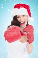 Composite image of festive brunette in boxing gloves punching