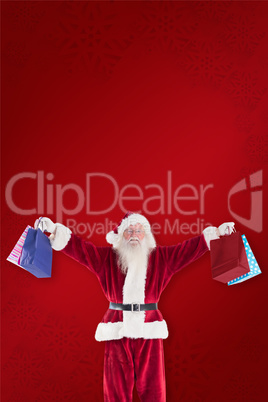 Composite image of santa holds some bags for chistmas