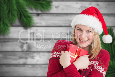 Composite image of woman holding christmas present