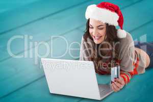 Composite image of smiling brunette shopping online with laptop