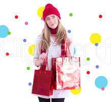 Composite image of pretty blonde holding shopping bags