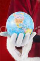 Composite image of santa has a globe in his hand