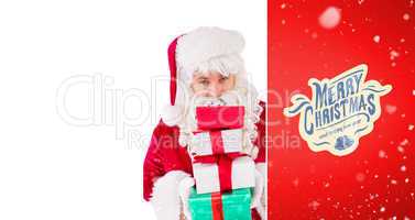 Composite image of smiling santa holding pile of gifts