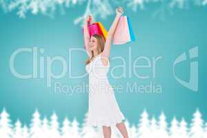 Composite image of excited blonde holding up shopping bags in wh