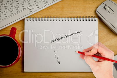 Composite image of hand writing new years resolutions