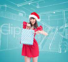 Composite image of festive brunette holding a gift bag