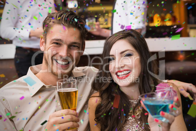 Composite image of happy couple having a drink together