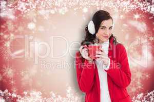 Composite image of woman in winter clothes holding a mug