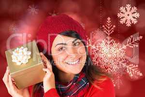 Composite image of pretty brunette in hat holding a gift