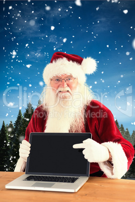 Composite image of happy santa showing laptop screen