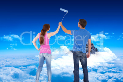 Composite image of couple painting a wall together