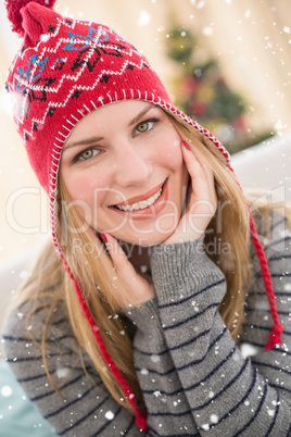 Composite image of portrait of a smiling pretty blonde in winter hat