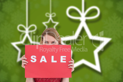 Composite image of cute blonde showing a red sale poster