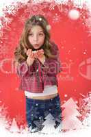 Composite image of festive little girl blowing over hands