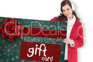 Composite image of happy brunette showing gift card