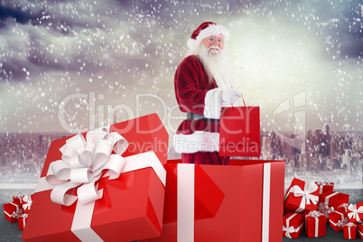 Composite image of santa standing in large gift