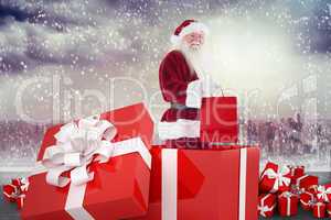 Composite image of santa standing in large gift