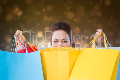 Composite image of happy brunette opening shopping bags