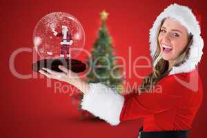 Composite image of sexy santa girl holding snow globe