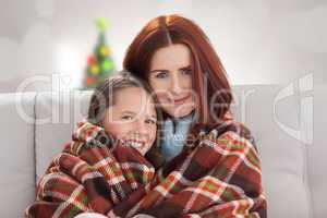 Composite image of mother and daughter under blanket