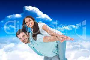 Composite image of happy casual man giving pretty girlfriend pig