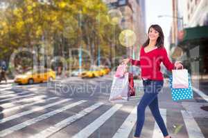 Composite image of excited brunette with shopping bags