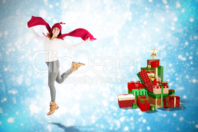 Composite image of happy brunette jumping and holding his scarf