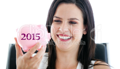 Composite image of laughing businesswoman holding a piggybank