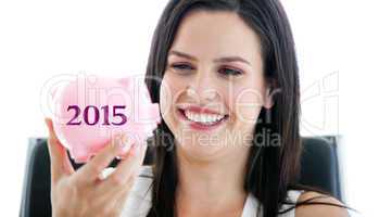 Composite image of laughing businesswoman holding a piggybank