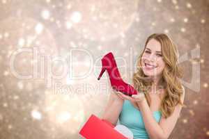 Composite image of elegant brunette admiring a shoe