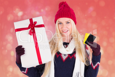 Composite image of festive blonde holding a gift Composite image of festive blonde holding a gift