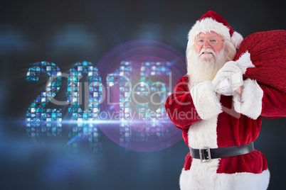 Composite image of santa carries his red bag and smiles