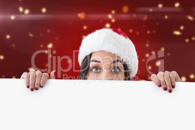 Composite image of festive brunette showing white poster