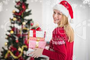 Composite image of blonde holding pile of gifts in front of the
