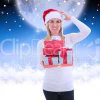 Composite image of stressed blonde in santa hat holding gifts