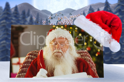 Composite image of santa claus writing his list with a quill