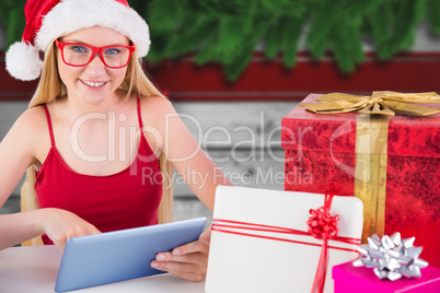 Composite image of festive blonde shopping online with tablet pc