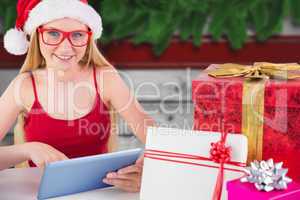 Composite image of festive blonde shopping online with tablet pc