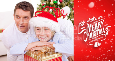 Composite image of smiling father and his son holding christmas