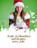 Composite image of pretty girl in santa costume holding gift box