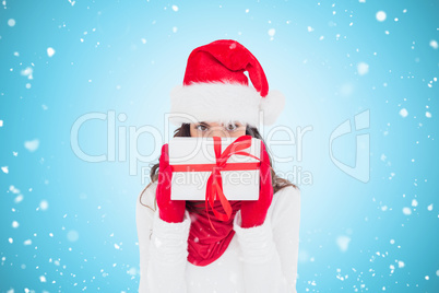 Composite image of brunette in red gloves and santa hat showing