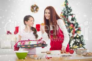Composite image of festive mother and daughter baking together