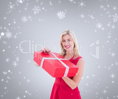 Composite image of pretty blonde opening gift