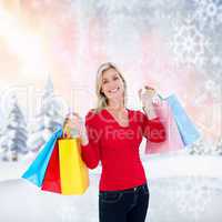 Composite image of happy blonde holding shopping bags