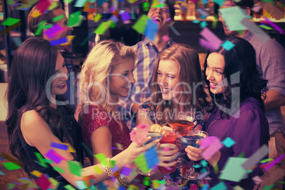 Composite image of happy friends drinking cocktails together